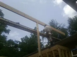 Carpenter setting a ridge beam over a new addition frame — Ice Dam Removal by Roofing Brothers in Douglas City