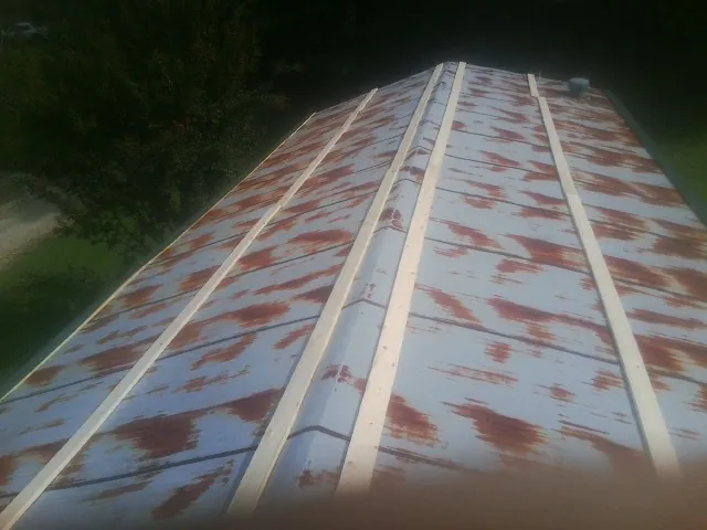 Rusted metal roof panels with new wood purlins before replacement — Storm Damage Roof Repair in Douglas City by Roofing Brothers