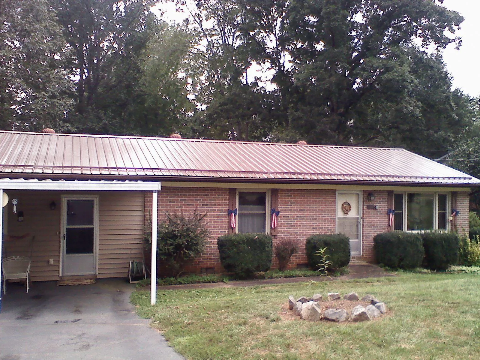 Bronze metal roof and carport on a brick ranch home — Roof Repair work by our crew in Douglas City